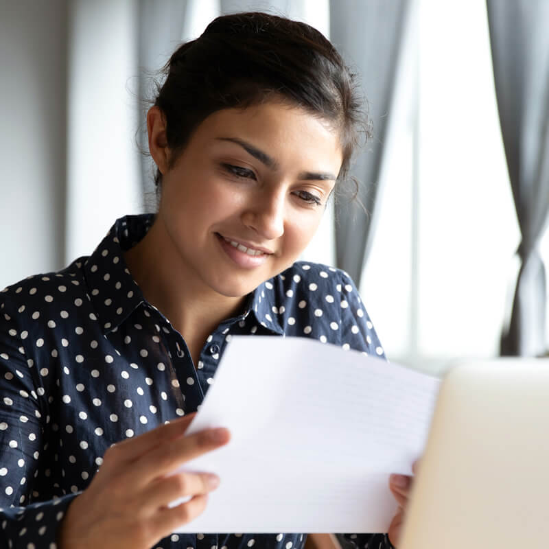 Adopting a Money-Smart Mindset A young happy lady looking at her personal finances.
