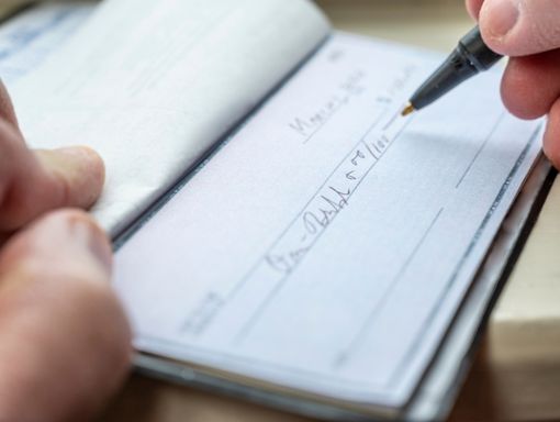 Checking Accounts from NCCYou Open checkbook with a pen filling out a new check