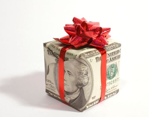 Courtesy Pay from NCCYou A small gift wrapped in money wrapping paper with a red bow on top