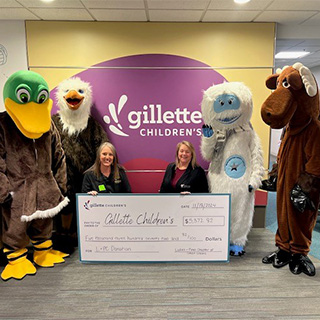Trina Hoff and NCCYou's mascott Earnie, poses for donation to Gillette's Children's Hospital