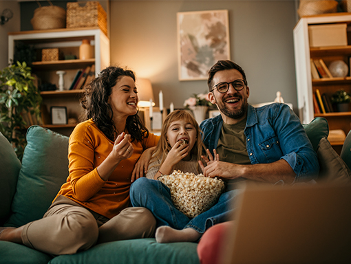 Estate Planning Services at NCCYou Family sitting on couch eating popcorn laughing at a television show