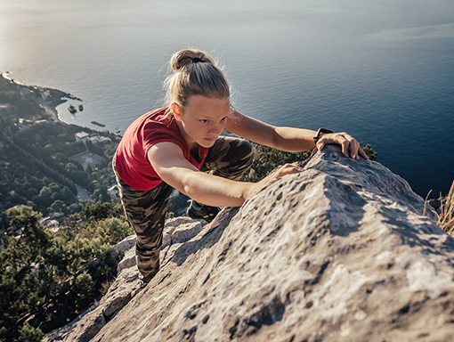 A young lady climbing up a mountain