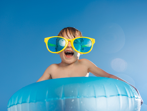 Young boy with funny glasses on a floaty